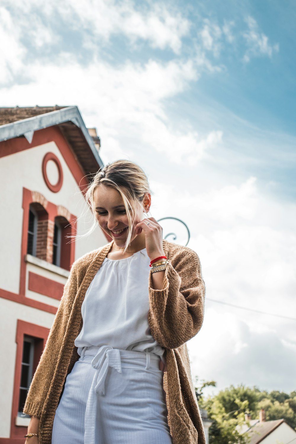 smiling woman standing near house