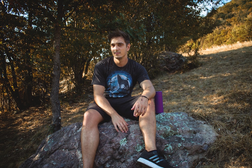 man sitting on stone at adytime