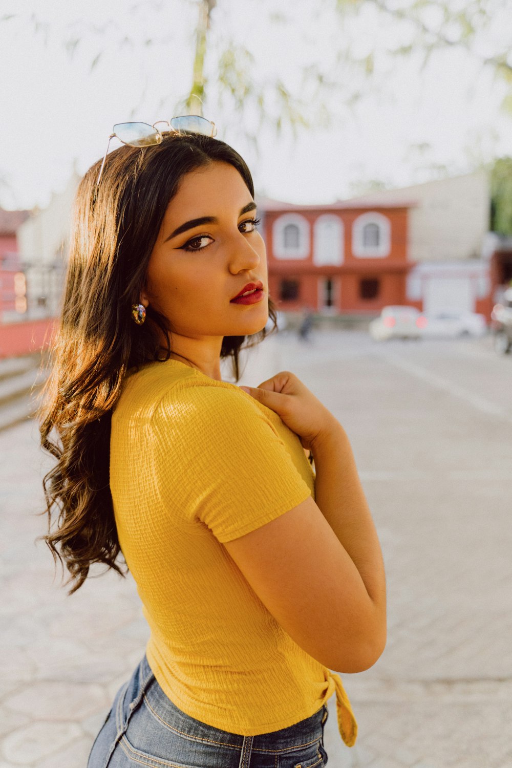 woman wearing yellow blouse standing while glancing her right side