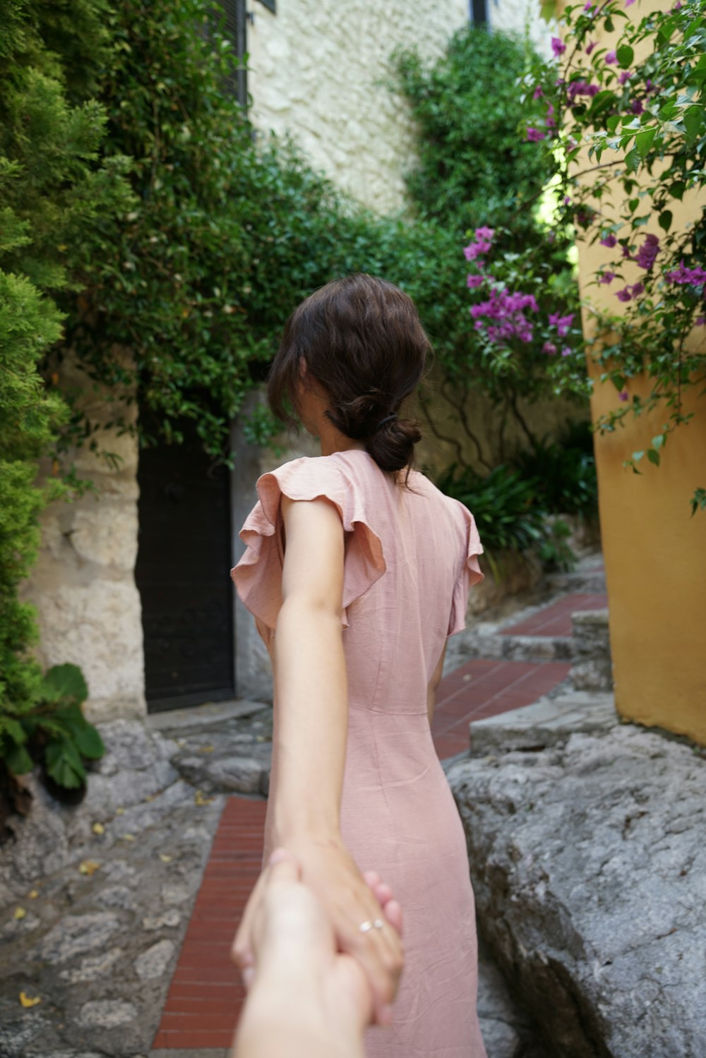 woman facing backward walking along narrow pathway