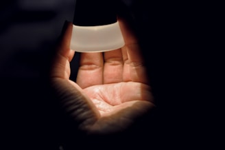 A hand placing a physical time capsule into a protective case shielded from light and electromagnetic waves