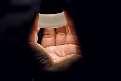A hand placing a physical time capsule into a protective case shielded from light and electromagnetic waves