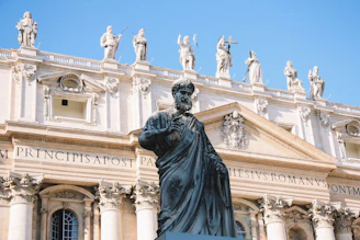 man statue beside concrete building during daytime
