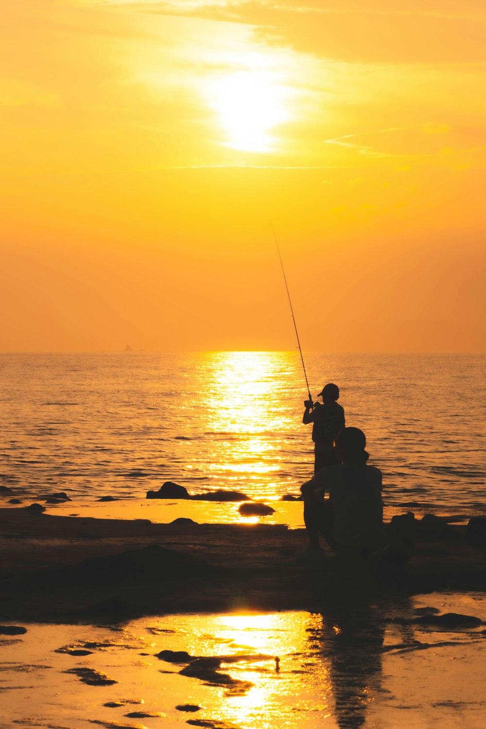 silhouette photography of person fishing on sea