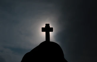 A dark fantasy style illustration of a monolithic cross silhouetted against a blood-red eclipse.