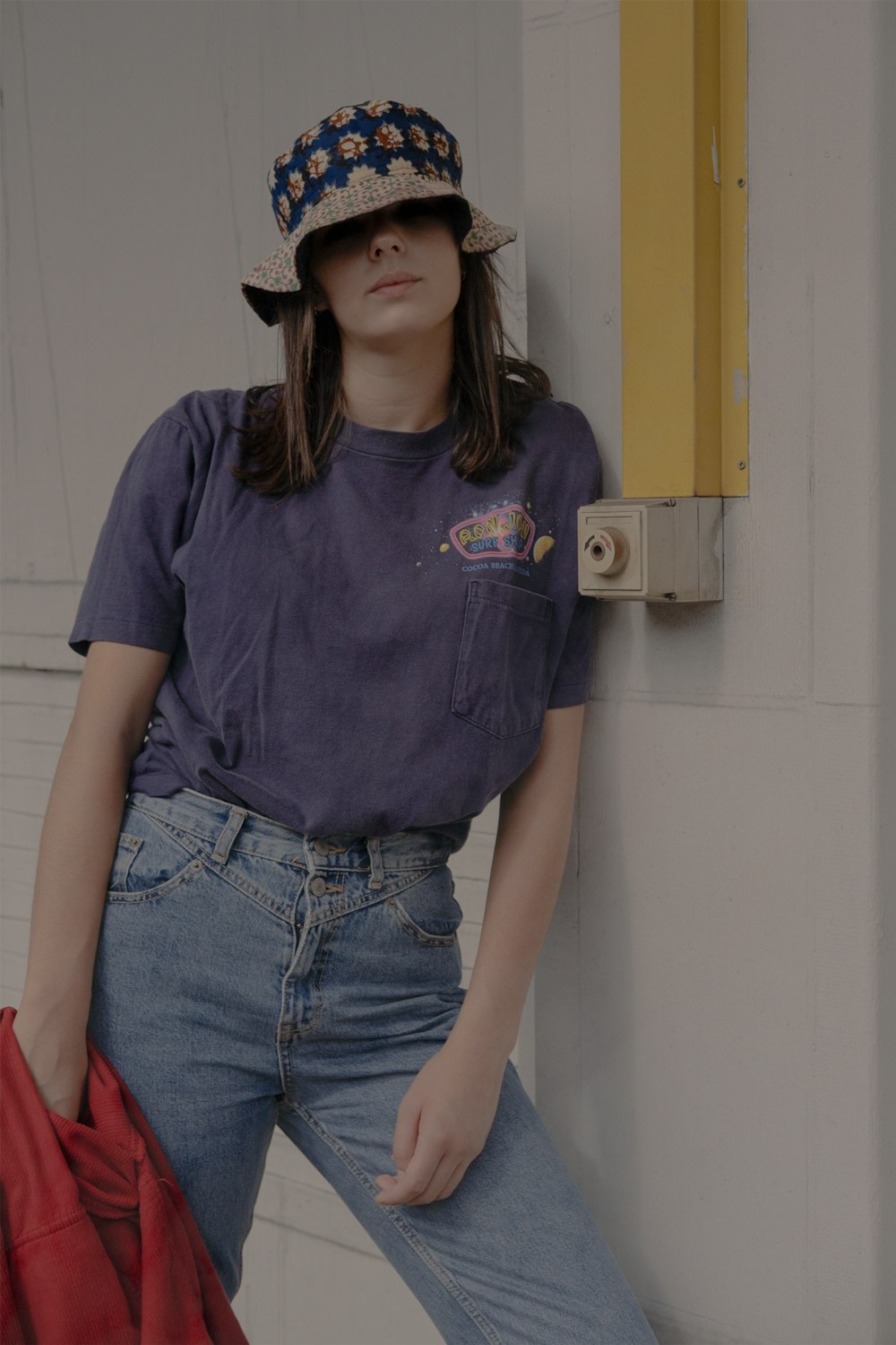 woman in gray shirt leaning on white wall