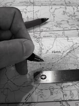 Close-up of hands working on route planning with maps and a laptop displaying load details.