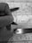 A monochrome image depicting a close-up of a hand holding a pen over a map. A ruler is also placed on the map, indicating measurements or planning activity. The map details roads and locations, with 'Paris' marked prominently.
