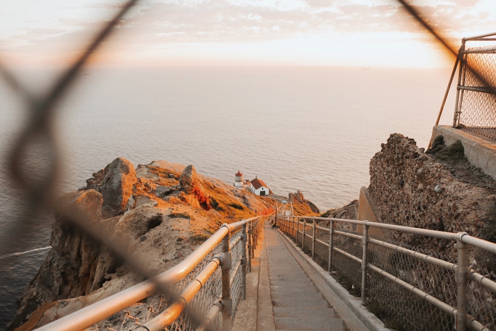 white wooden footbridge viewing sea during daytime