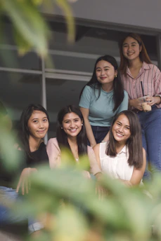 A serene portrait of a diverse group of women smiling together in soft natural light.