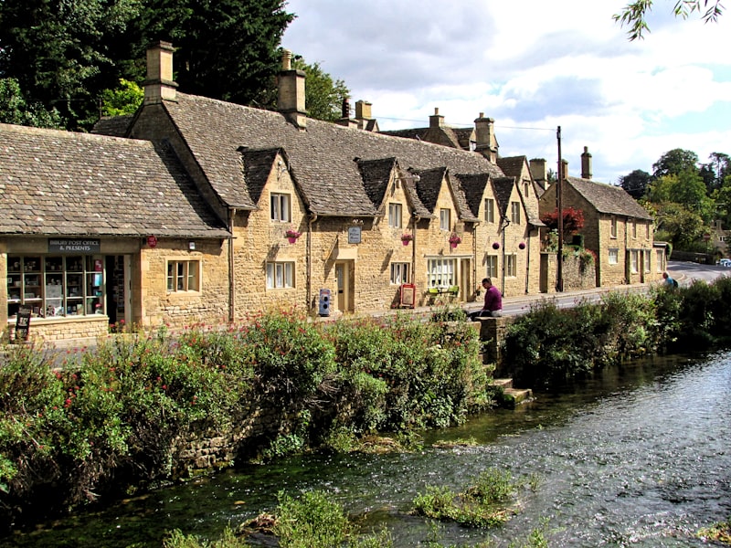 Stone cottages and river in a Cotswolds village, England