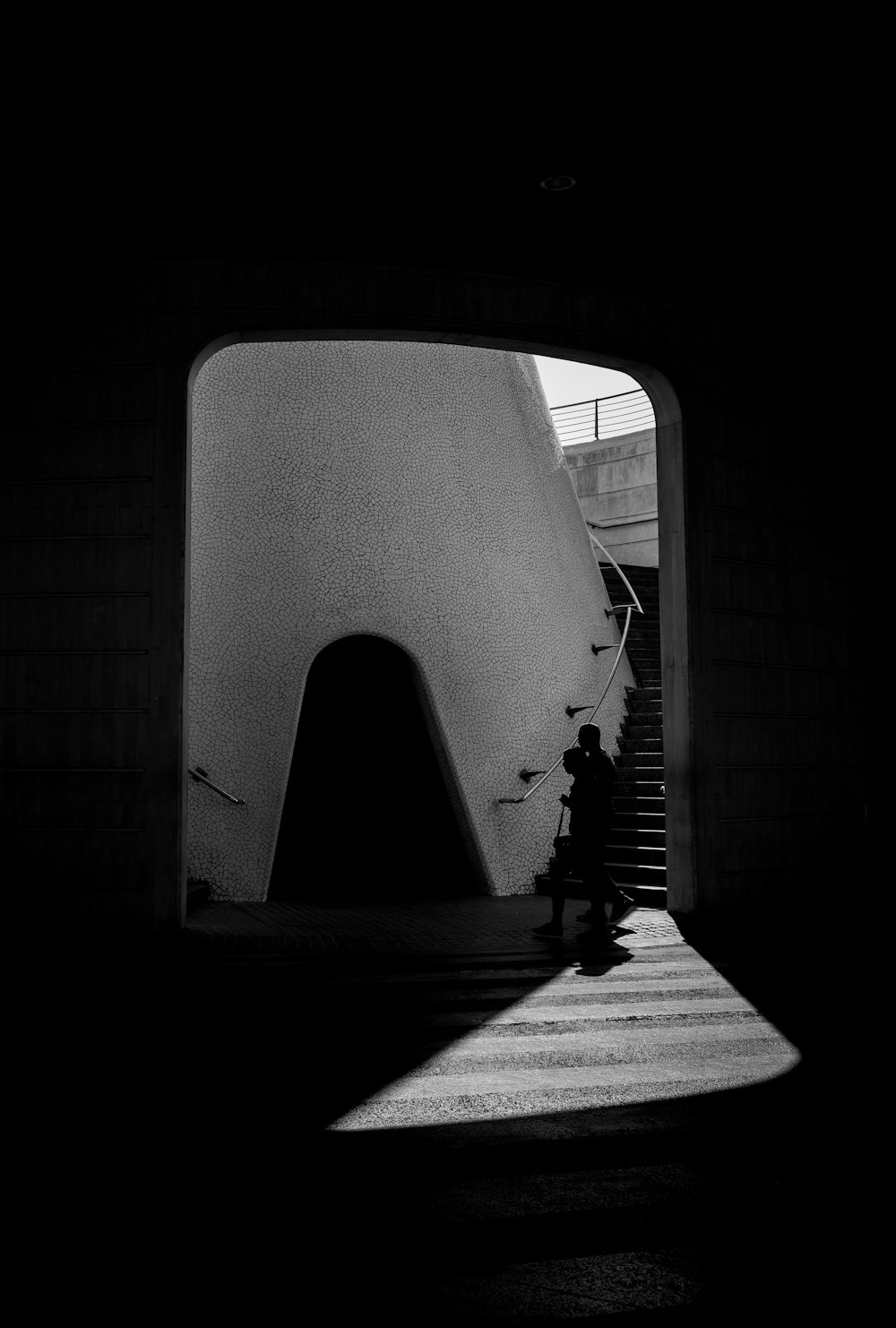 a black and white photo of a person walking up stairs