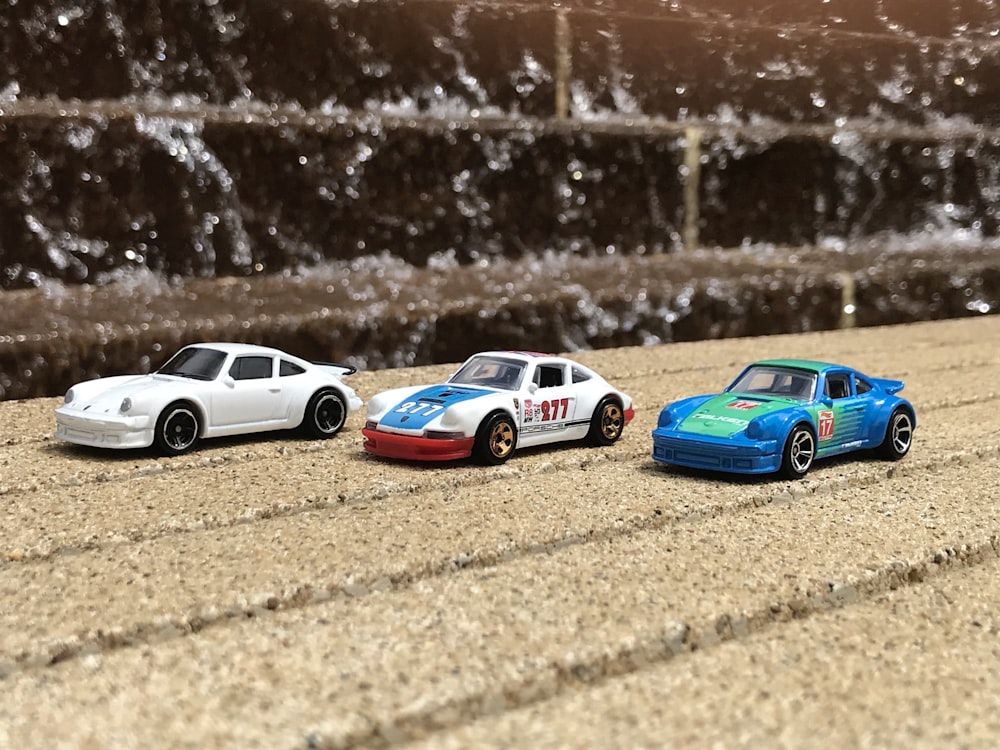three assorted-color car toys