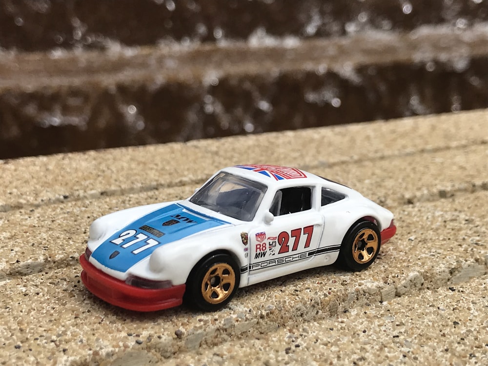 Fotografia a fuoco selettiva del giocattolo coupé da corsa 277 bianco e blu