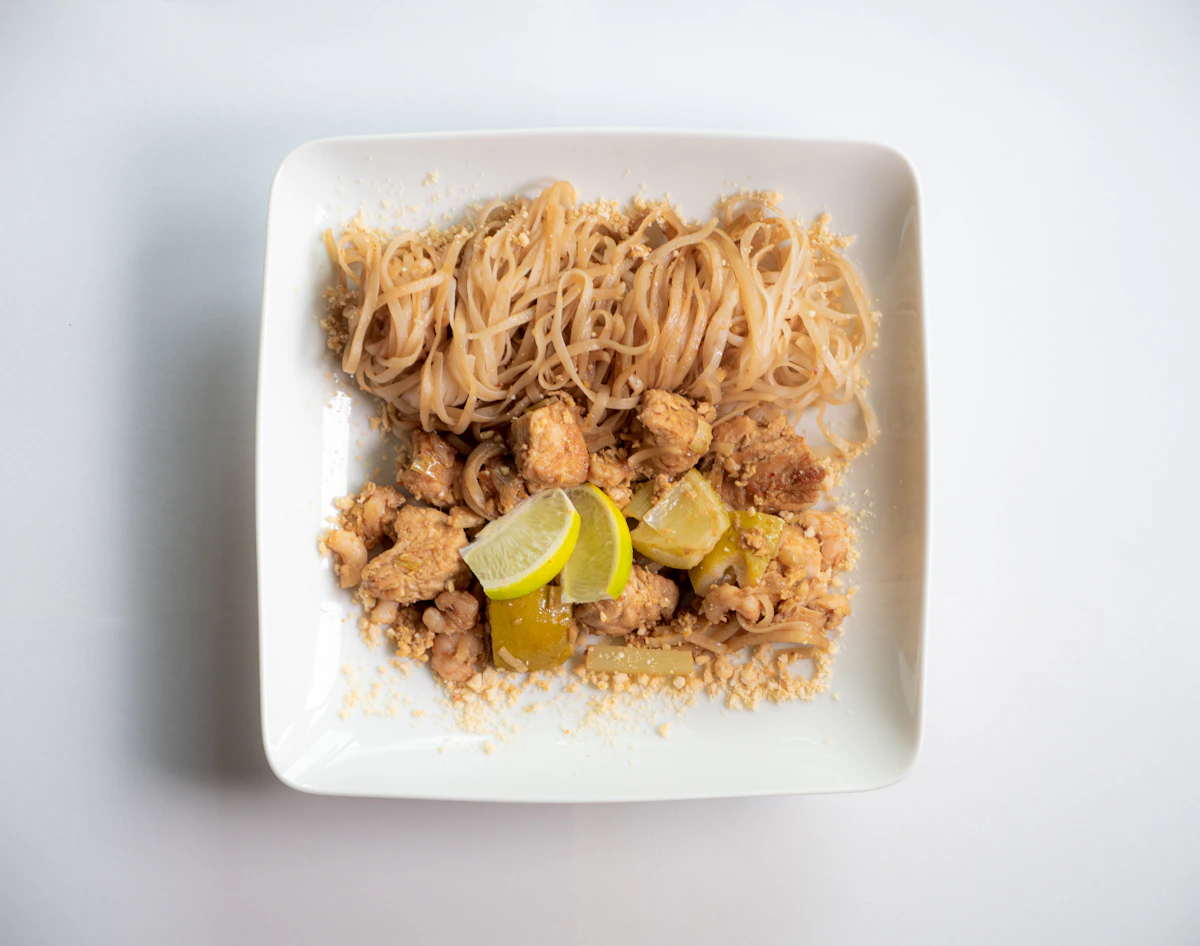 Pad Thai noodles with herbs and lime, featured in From Wok to Table: Keeping Thai Noodles Bright at Home