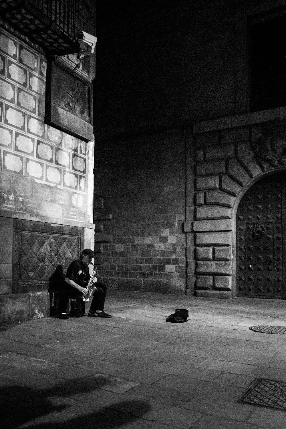 man sits beside the building