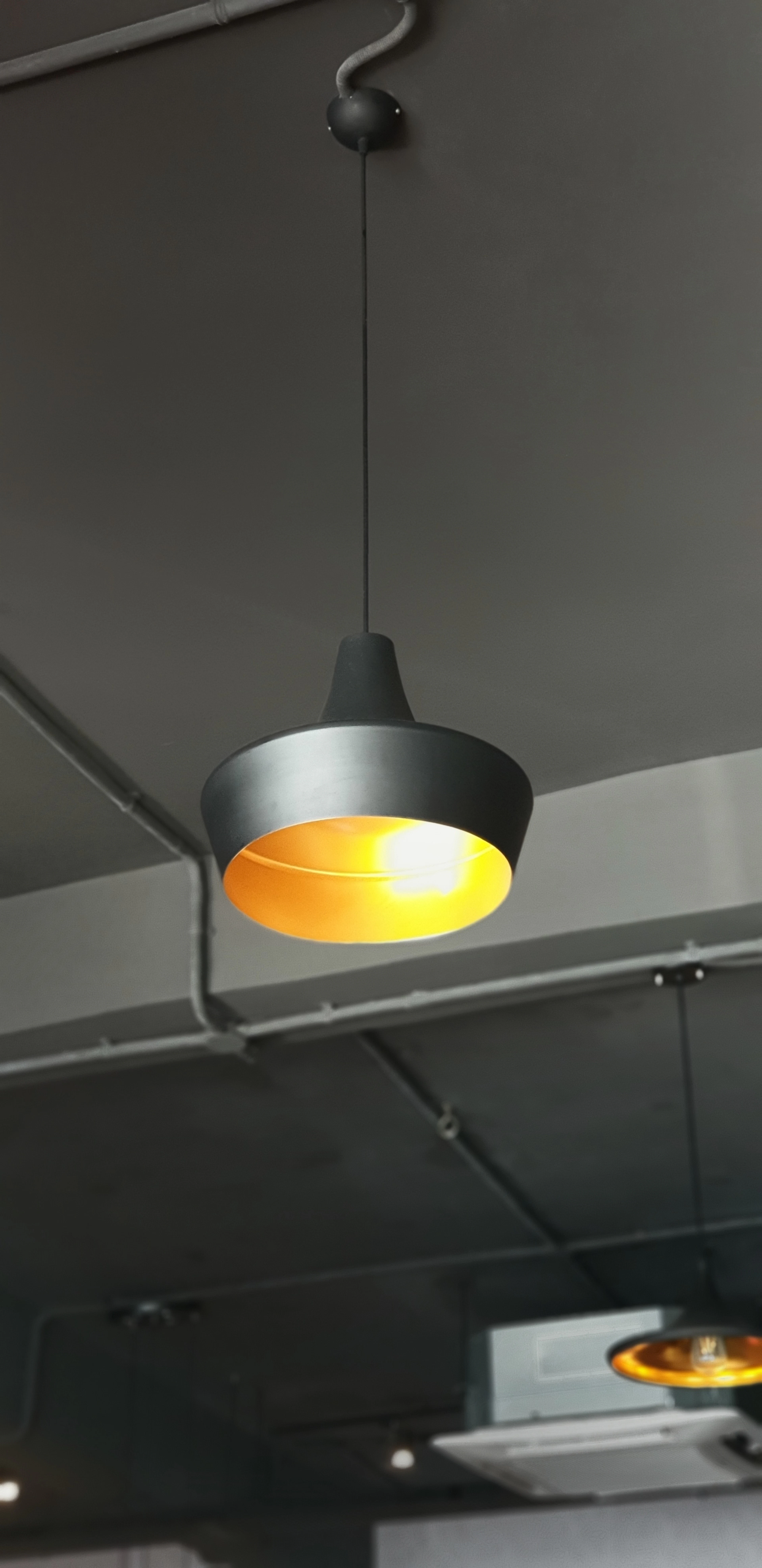 Two turned-on gray pendant lamps