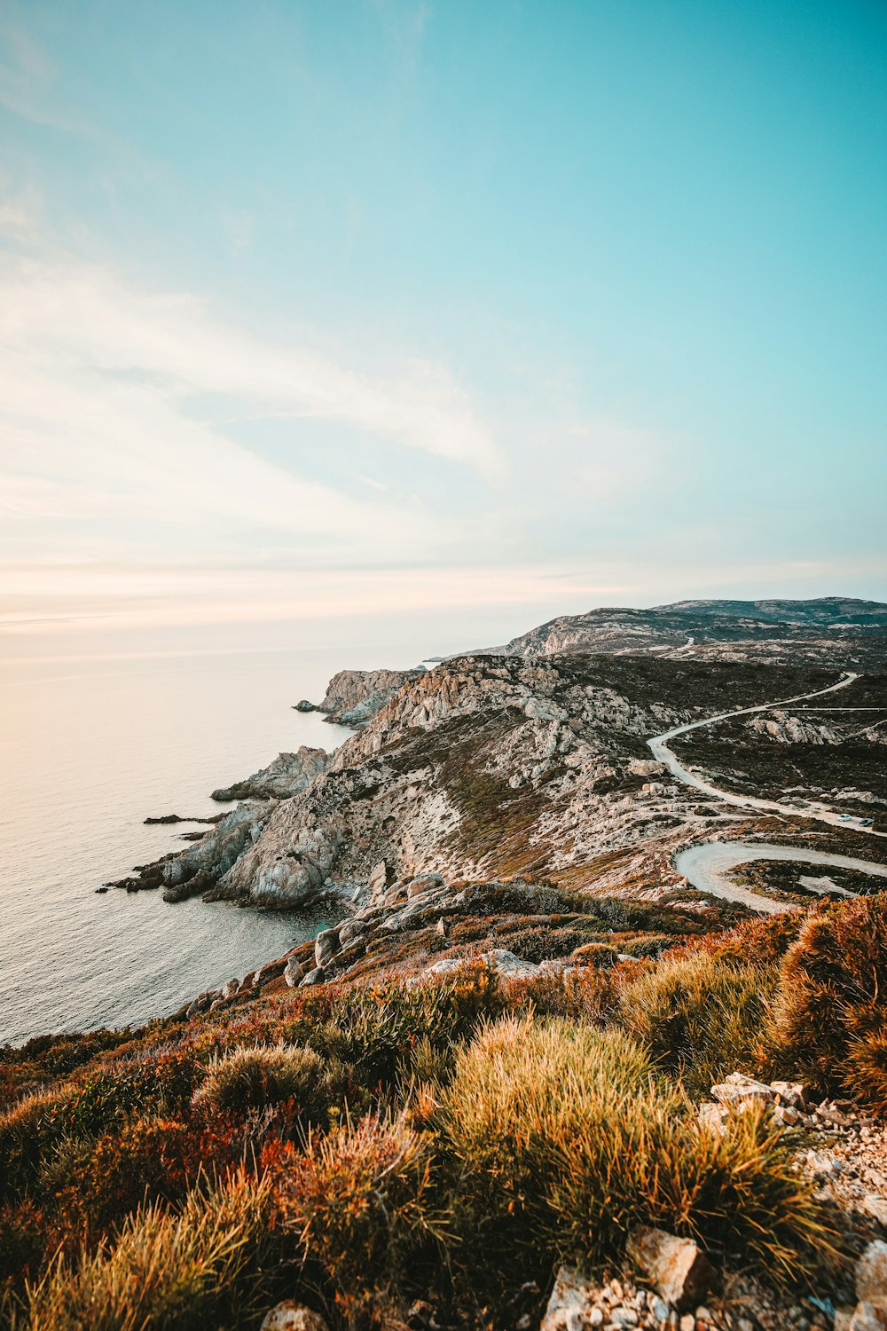 rocky cliff facing ocean under blue sky