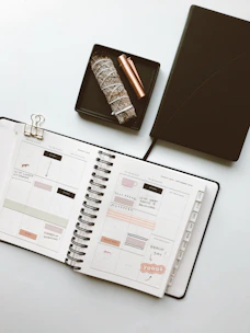 A serene flat lay of a calming printable planner surrounded by soft beige and sage green accents.