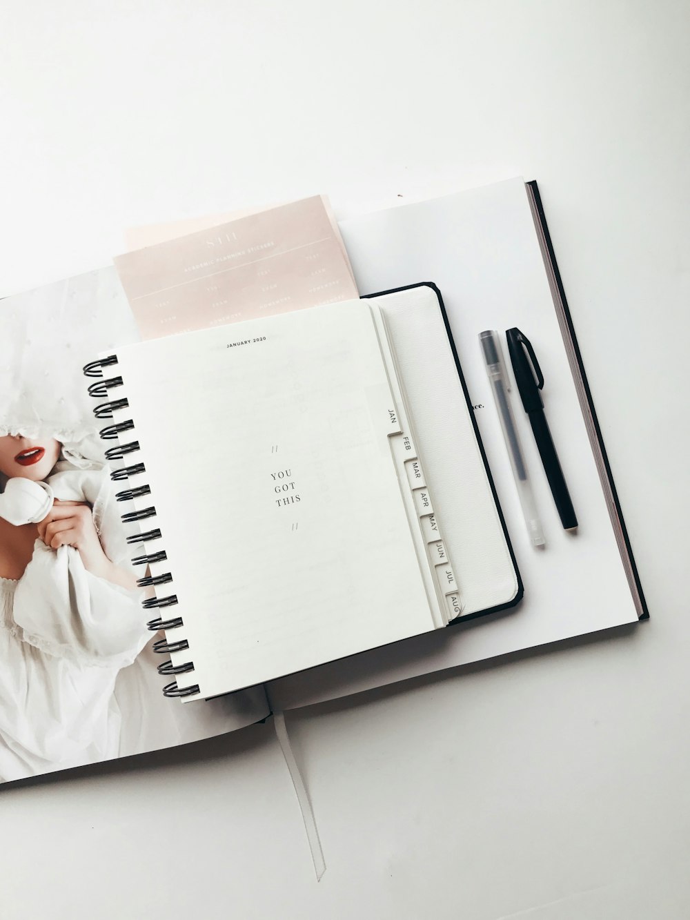 white notebook near pens