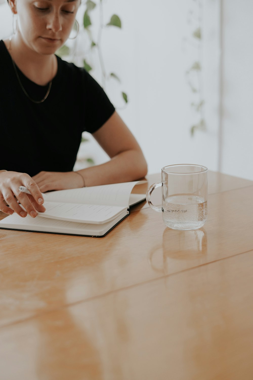 person reading book near filled cup