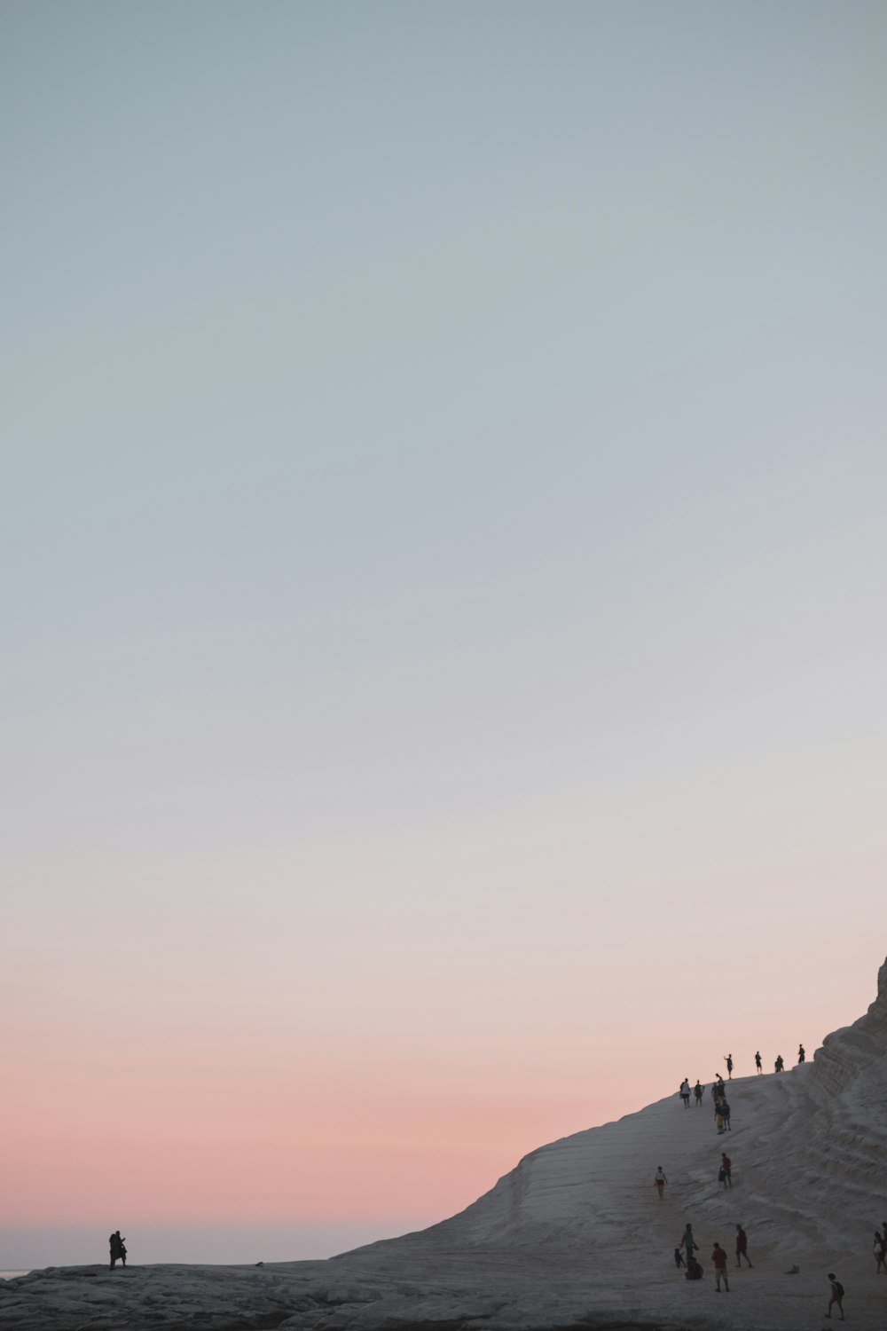 a group of people standing on top of a sandy beach