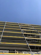 Photo of sturdy scaffolding set up on a construction site under a clear sky