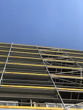 Photo of sturdy scaffolding set up on a construction site under a clear sky