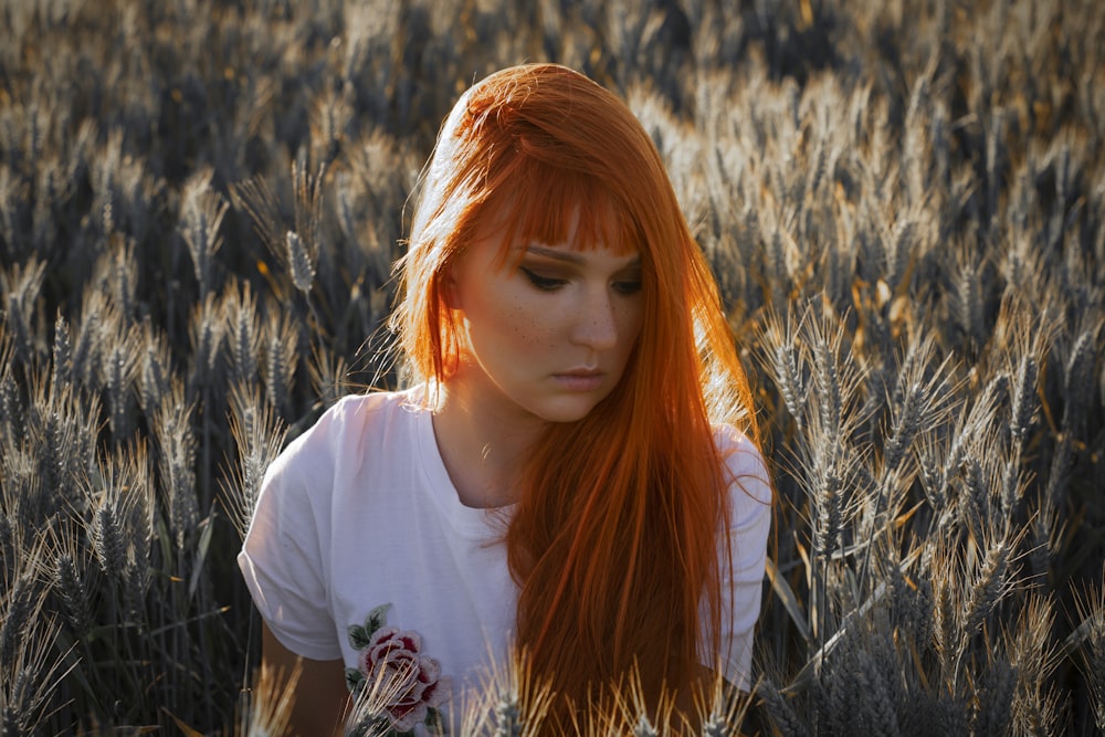 woman sitting on grass field at daytime