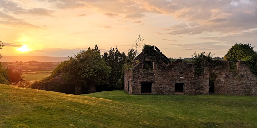 A serene landscape blending ancient ruins with modern pathways under a golden sunset.