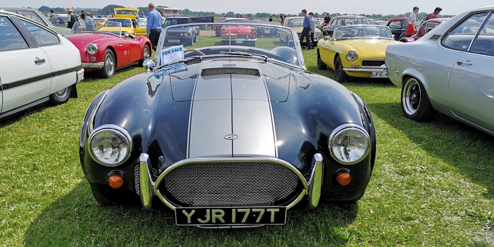 vintage black car parked on grass field during daytime