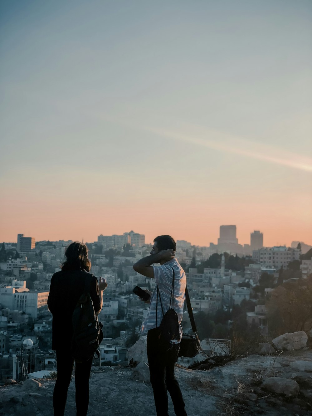 man and woman standing front of buildings