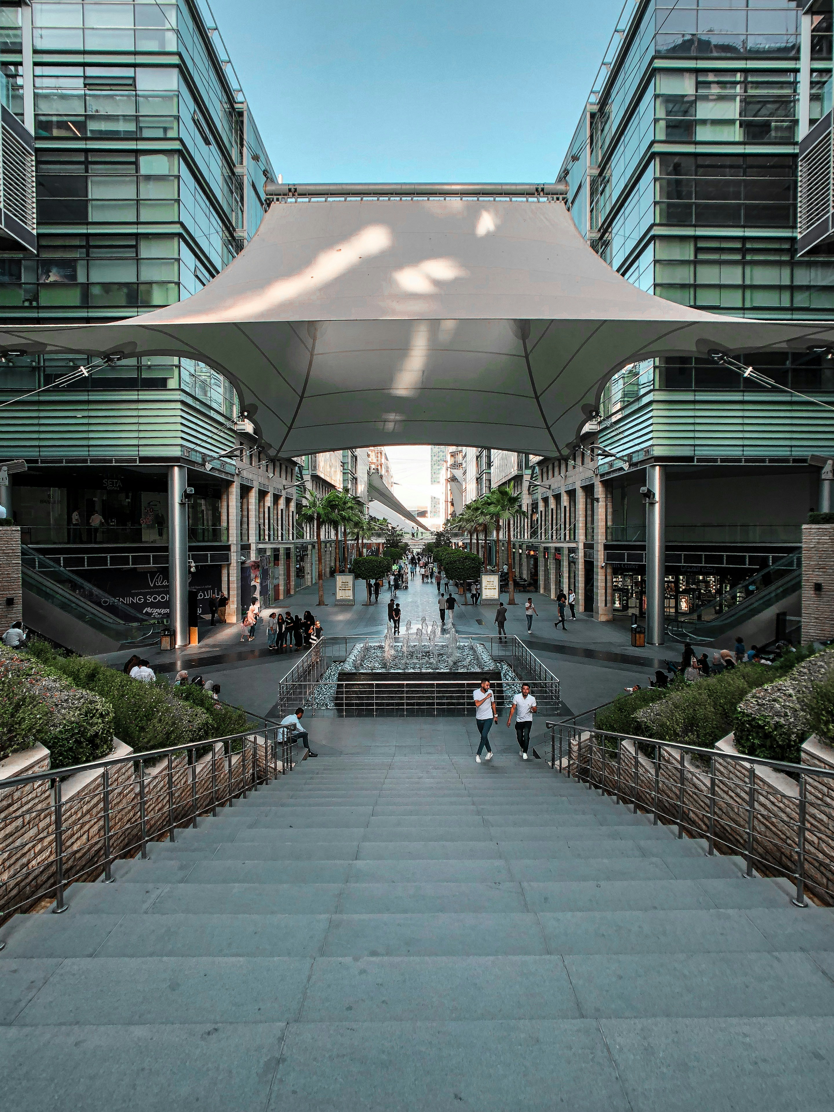 a group of people walking down a street under a canopy