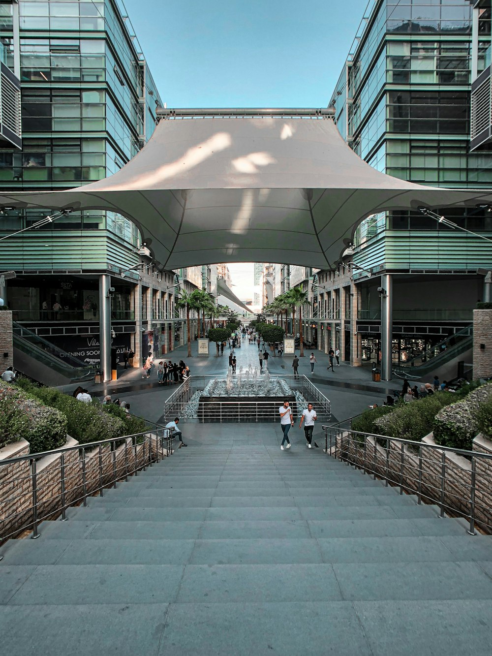 a group of people walking down a street under a canopy