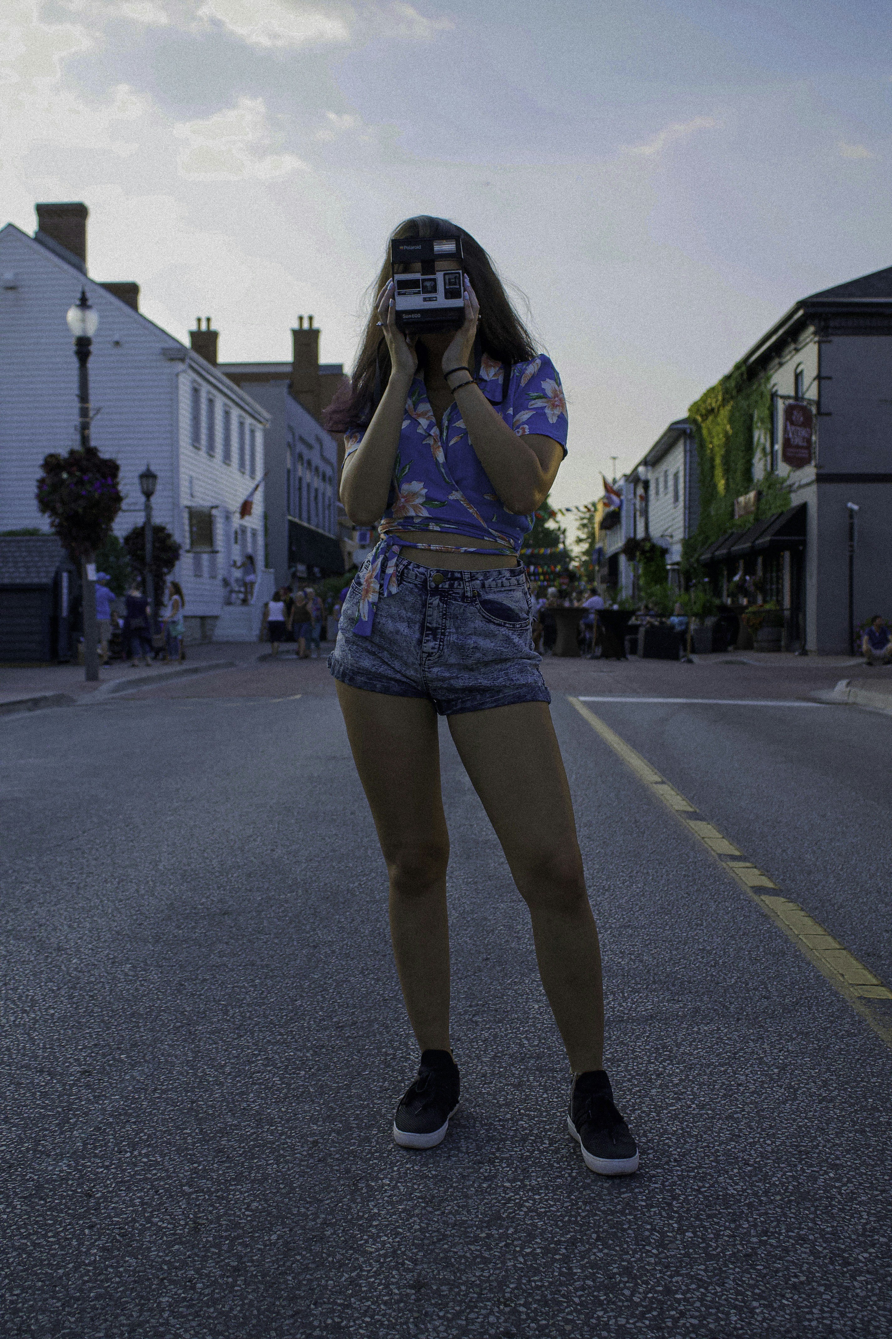 woman standing on road using camera