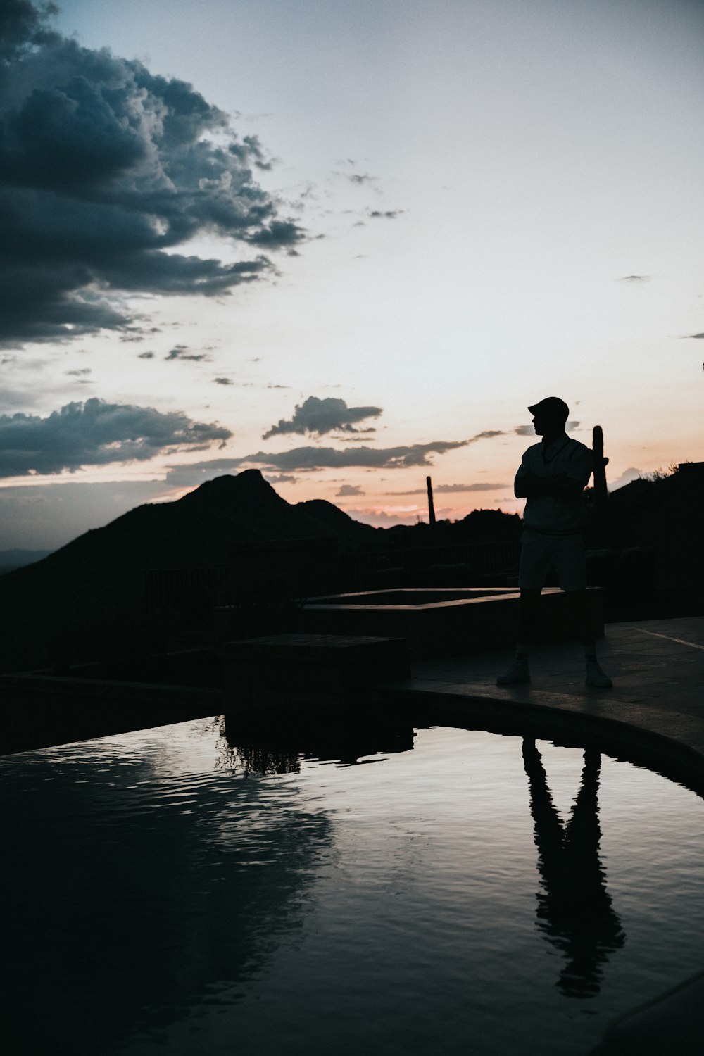 silhouette of man standing in front of pool