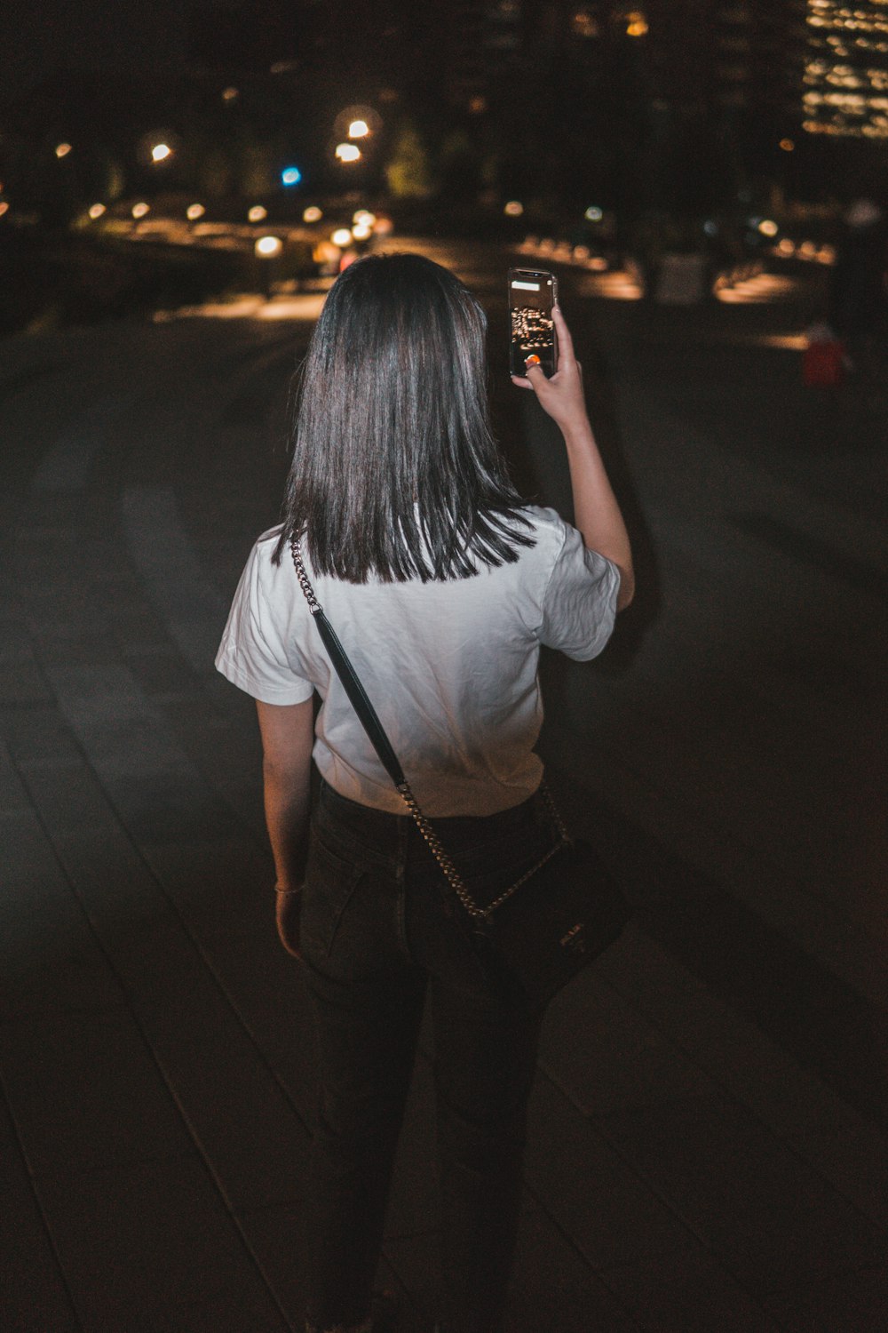 donna in piedi e usando lo smartphone durante la notte