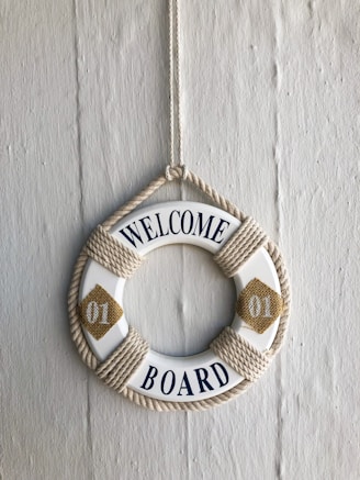 a Welcome message on a hanging white and brown swim ring 