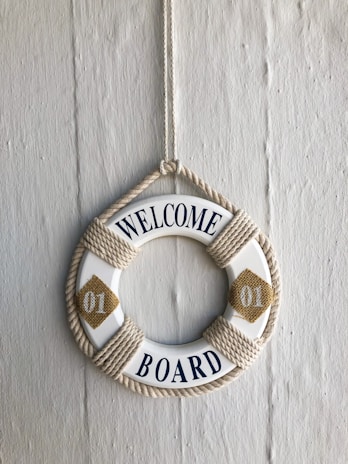 a Welcome message on a hanging white and brown swim ring 