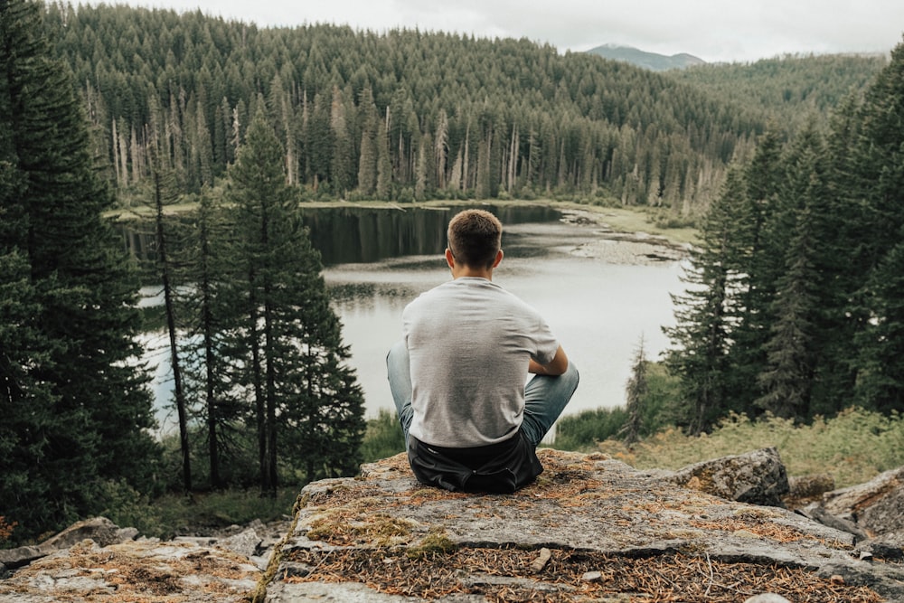 man sitting near lake