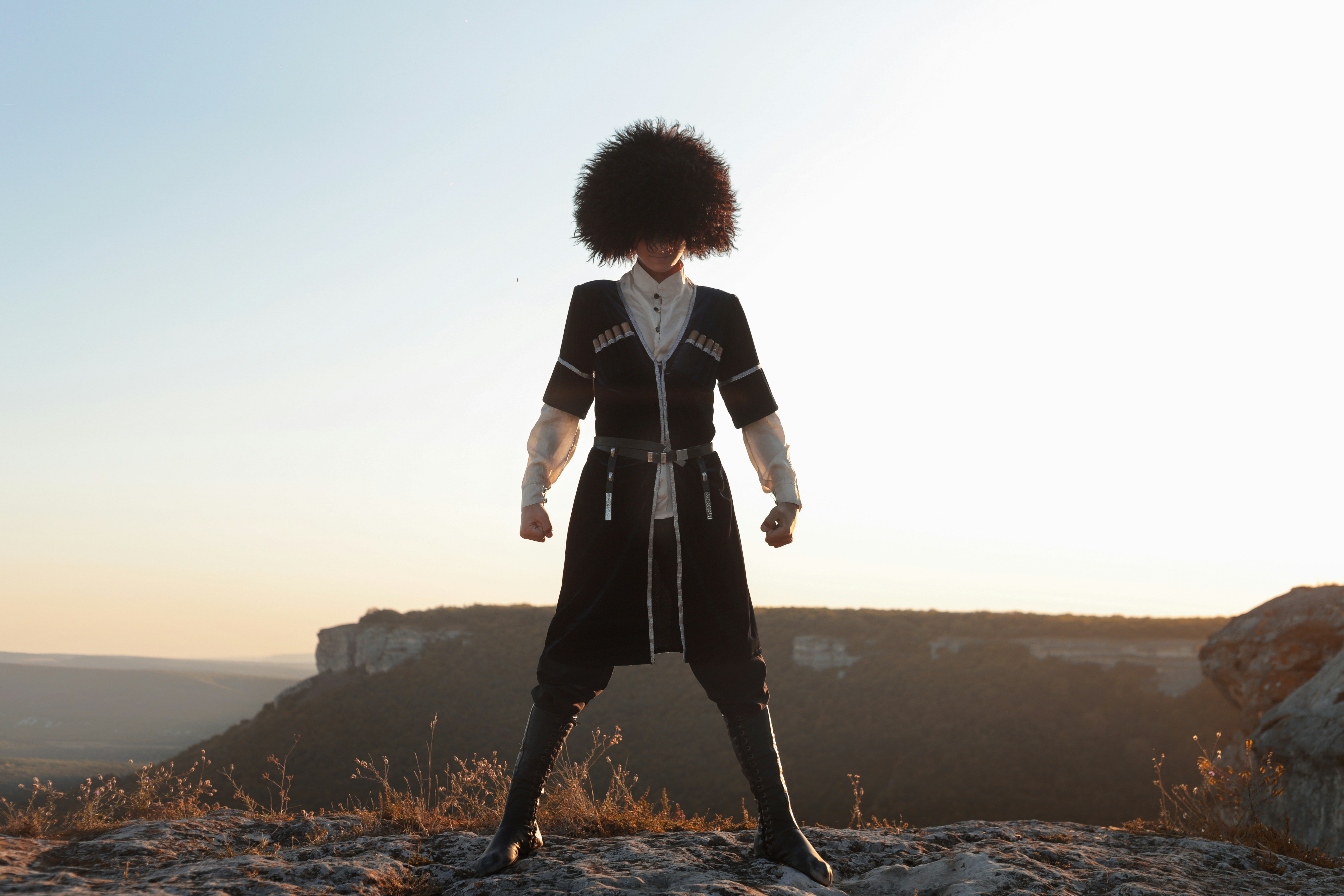 persona in cappotto bianco e nero sulla scogliera