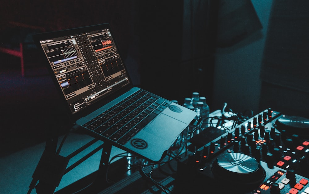 a laptop computer sitting on top of a mixing desk