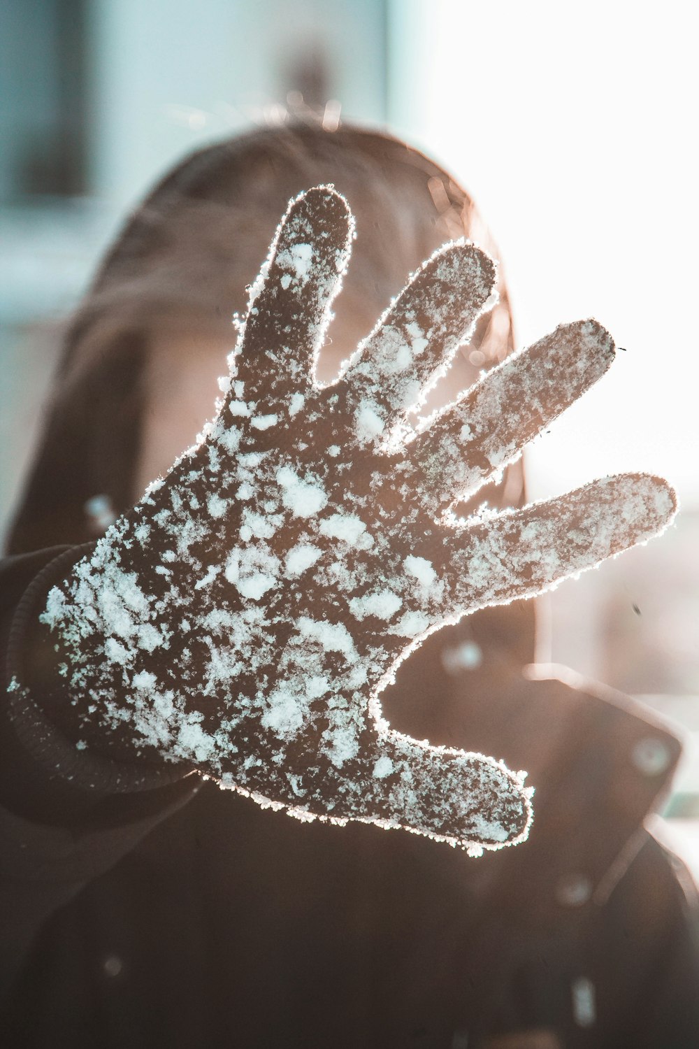 person wearing coat covering her face