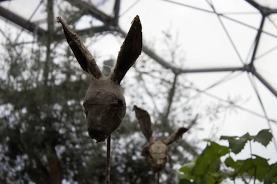 Close-up of a whimsical rabbit sculpture made from recycled materials in natural light.