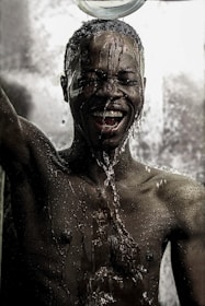 Close-up of excited faces soaking wet after a daring river rapid run, sun-teal water droplets sparkling.
