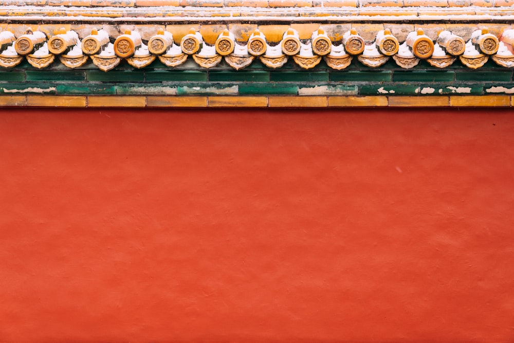 un primo piano di un muro rosso con finiture gialle e verdi