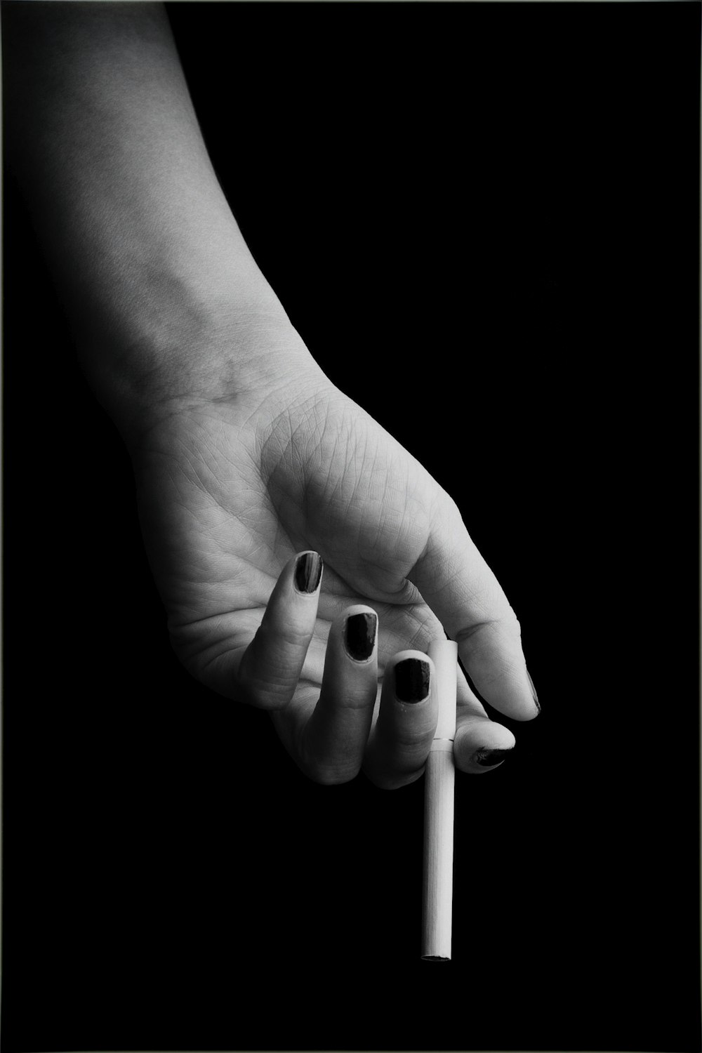 person holding single cigarette stick
