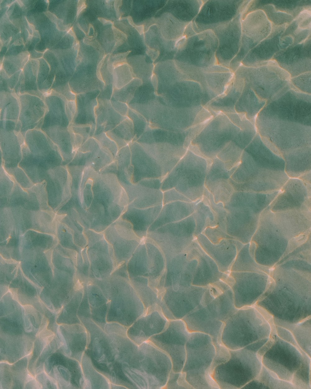 Das Wasser reflektiert das Sonnenlicht auf dem Sand