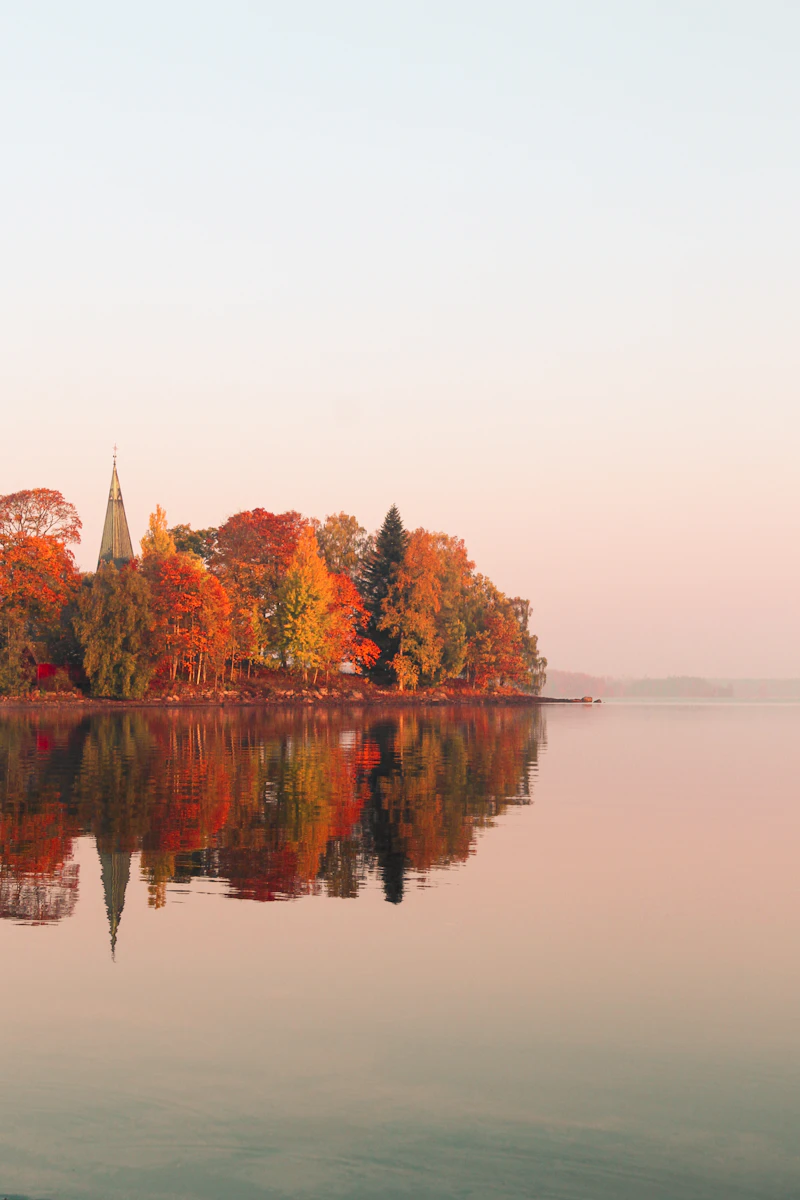 Orange and green trees near a lake
