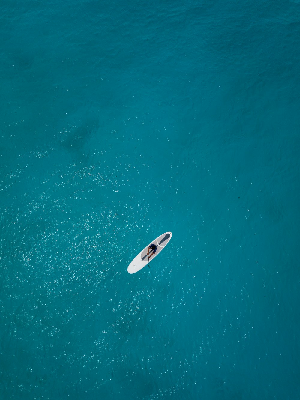 persona che cavalca sulla tavola da surf bianca